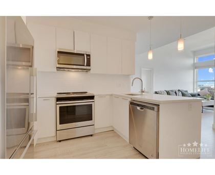 A modern kitchen with stainless steel appliances and white cabinets.