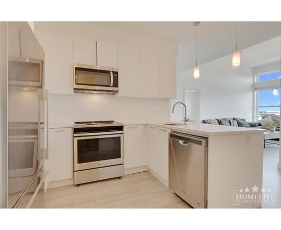 A modern kitchen with stainless steel appliances and white cabinets.