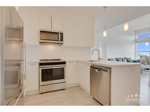 A modern kitchen with stainless steel appliances and white cabinets.