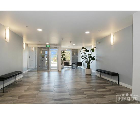 A spacious hallway with wooden floors and benches on either side.