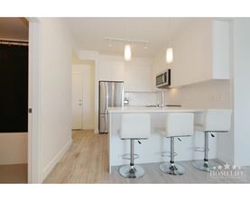 A kitchen with white chairs and a bar stool.