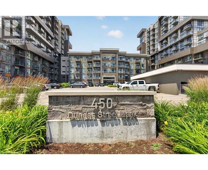 A concrete sign with the number 450 on it is in front of a parking lot.