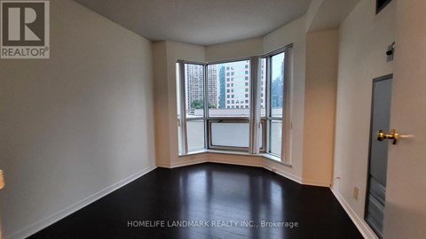 A room with a large window and a view of a building outside.