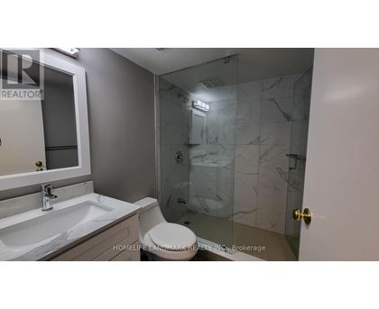 A bathroom with a sink, toilet, and shower.
