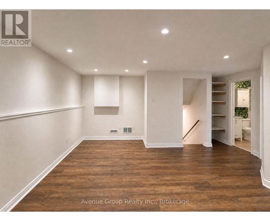 A large empty room with wooden floors and white walls.