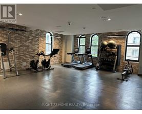 A gym with a brick wall and various exercise equipment.