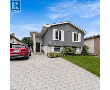 A modern house with a grey exterior and a red car parked in front.