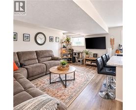 A living room with a grey sofa, a coffee table, and a bar area.