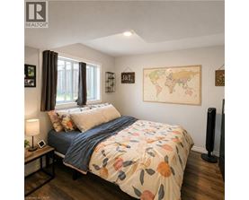 A bedroom with a bed, nightstand, lamp, and a world map on the wall.