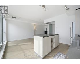A spacious kitchen with white cabinets and a black countertop.