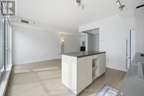 A spacious kitchen with white cabinets and a black countertop.