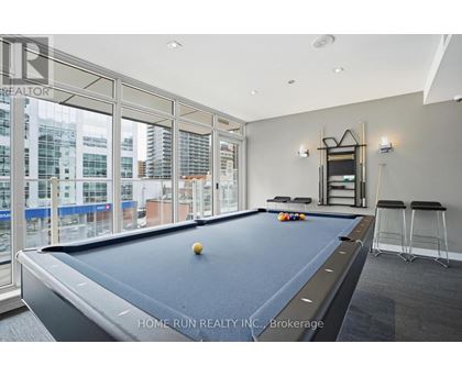 A pool table in a room with a view of the city.