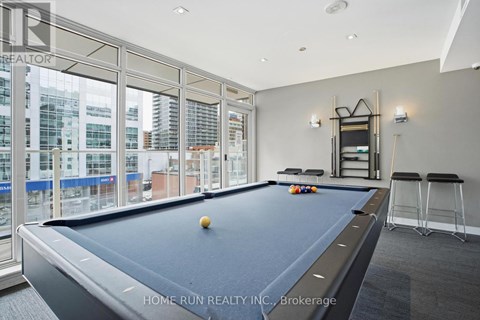 A pool table in a room with a view of the city.