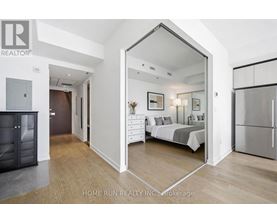 A bedroom with a bed, dresser, and mirror is shown in a real estate listing.