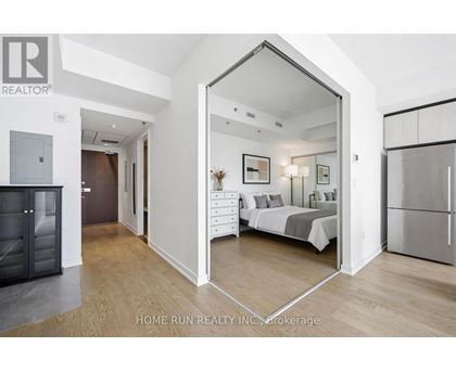 A bedroom with a bed, dresser, and mirror is shown in a real estate listing.