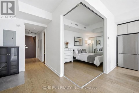 A bedroom with a bed, dresser, and mirror is shown in a real estate listing.