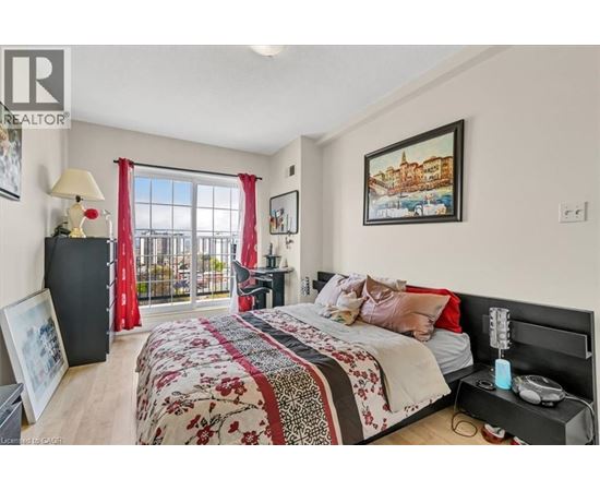 A bedroom with a large bed and a balcony with red curtains.