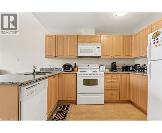 A kitchen with wooden cabinets and white appliances.