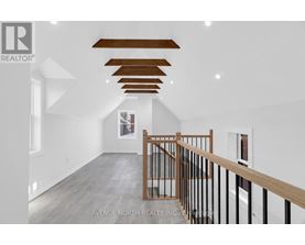 A spacious room with a wooden staircase and white walls.
