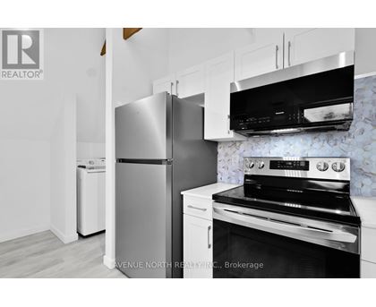 A modern kitchen with a stainless steel refrigerator and oven.