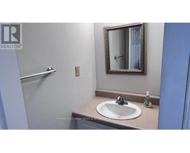 A bathroom with a sink, mirror and towel rack.