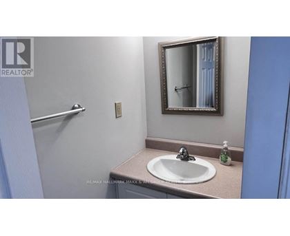 A bathroom with a sink, mirror and towel rack.