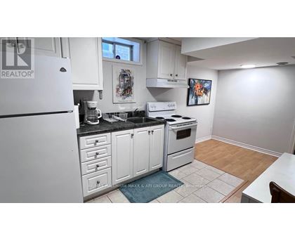 A kitchen with white cabinets and appliances, a fridge, a stove, and a dining table.
