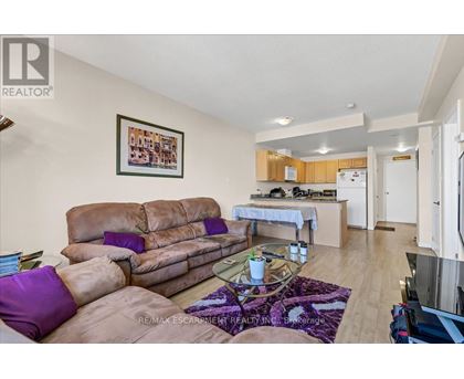 A living room with a brown couch and a purple pillow.