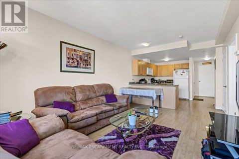 A living room with a brown couch and a purple pillow.