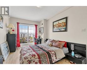 A bedroom with a large bed and a balcony with red curtains.