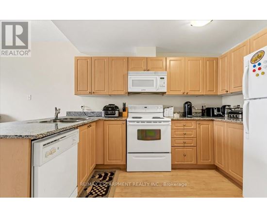 A kitchen with wooden cabinets and a white refrigerator.