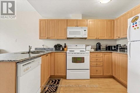 A kitchen with wooden cabinets and a white refrigerator.