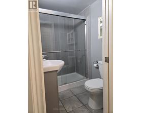 A bathroom with a toilet, sink, and shower.