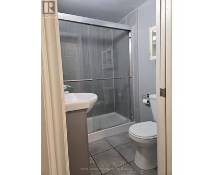 A bathroom with a toilet, sink, and shower.