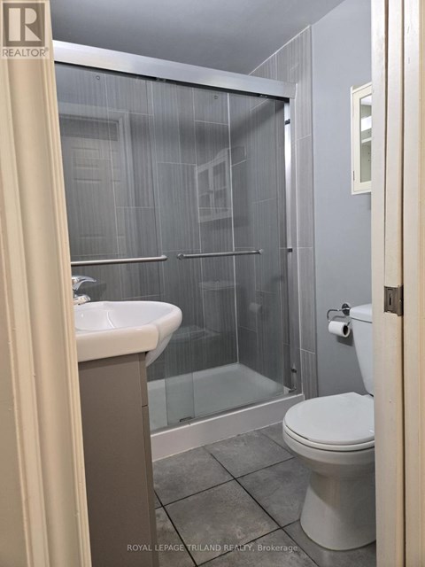 A bathroom with a toilet, sink, and shower.