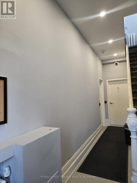 A hallway with a staircase and a door.