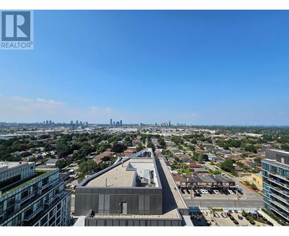 A cityscape with a clear blue sky and a building with the logo REALTOR in the top left corner.