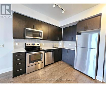 A kitchen with black cabinets and stainless steel appliances.