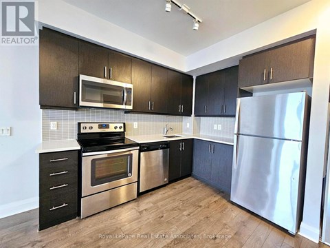 A kitchen with black cabinets and stainless steel appliances.