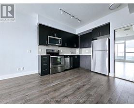 A modern kitchen with black cabinets and stainless steel appliances.