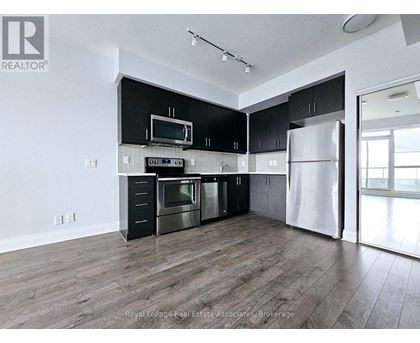 A modern kitchen with black cabinets and stainless steel appliances.