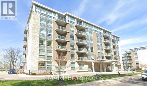 A modern apartment building with balconies and a clear sky in the background.