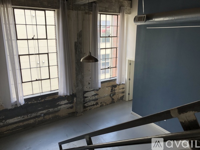A room with a large window and a hanging light fixture.
