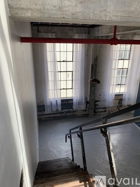 A staircase in a building with a red beam above it.