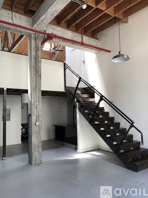 A large open space with a staircase and a hanging light fixture.