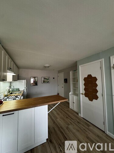 A kitchen with white cabinets and a wooden countertop.