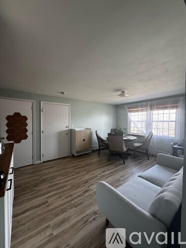 A living room with a white couch and a wooden floor.