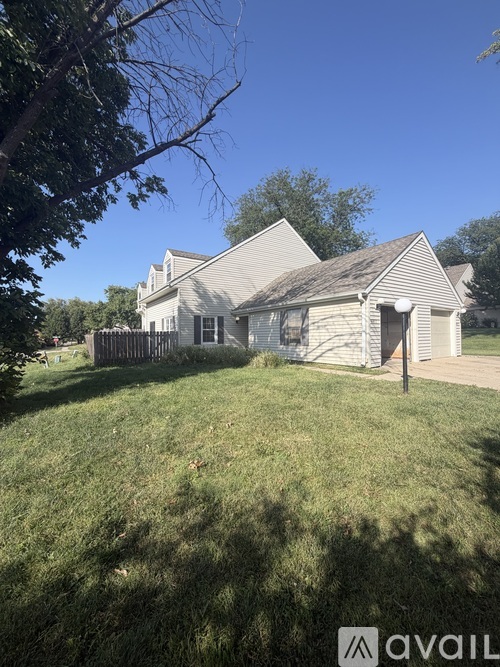 A house with a white fence and a tree in front of it.