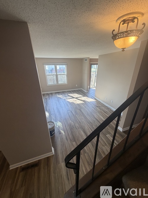 A room with wooden floors and a staircase with a metal railing.