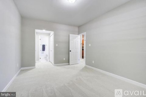A spacious room with two doors and a carpeted floor.